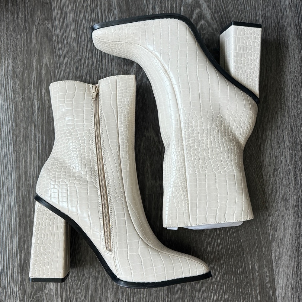White ankle croc style boots with black trim and zipper